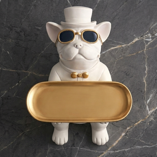 White dog figurine with sunglasses and a top hat holding a gold tray on a dark marble background