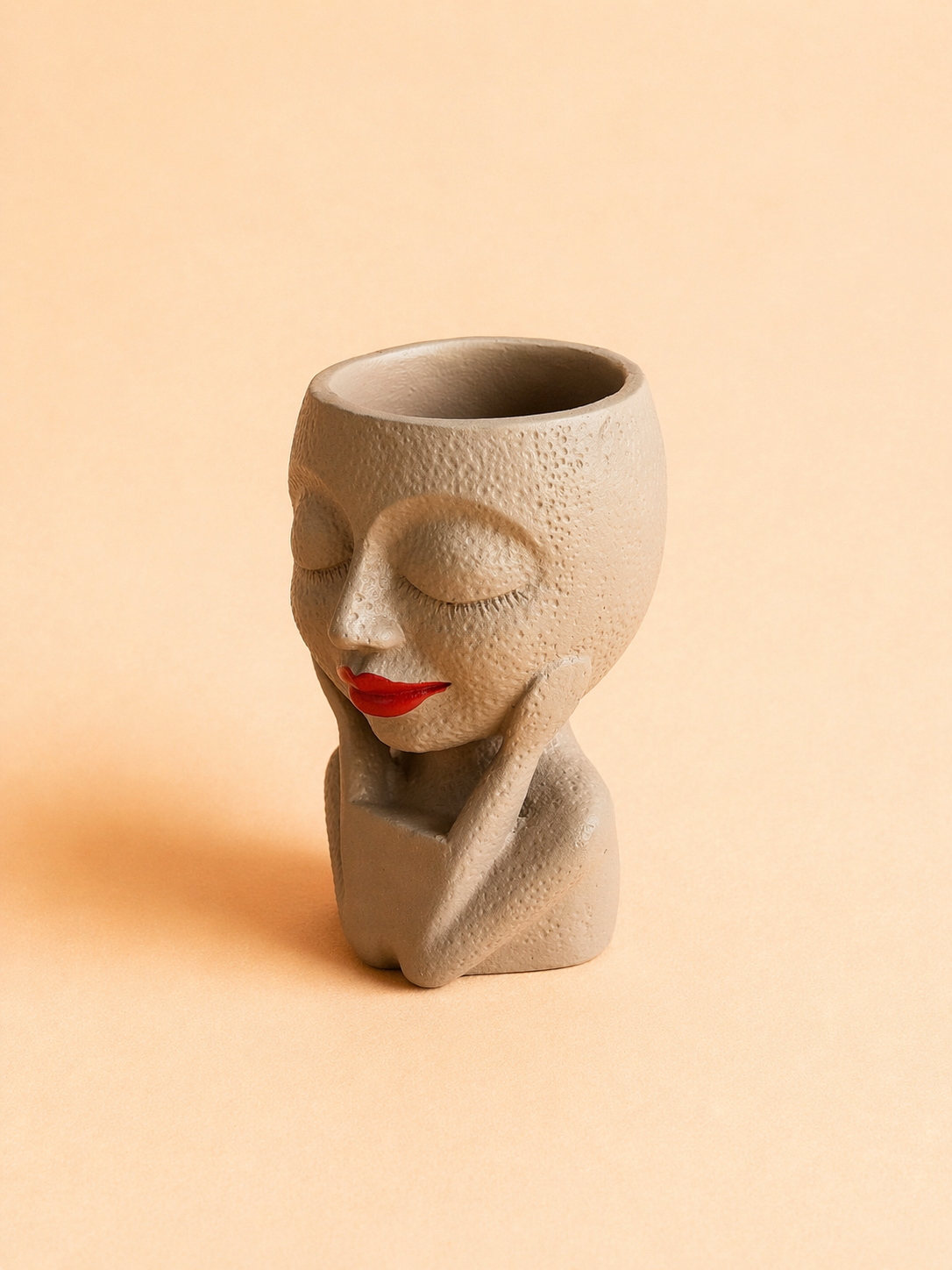 Handcrafted face planter decor featuring a serene lady head pot with closed eyes and red lips.